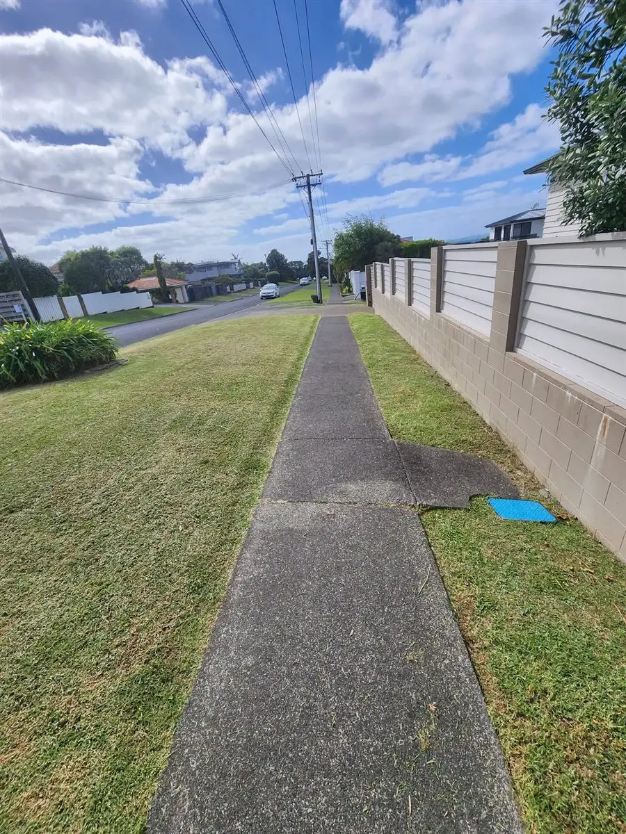 Freshly mowed and edged grass berm along a suburban footpath