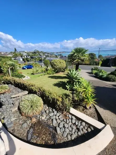 Tidy front garden and mown lawn with a North Shore harbour view